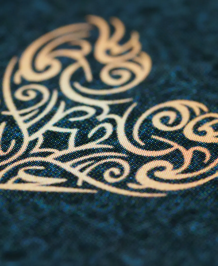 A gold ornamental heart pattern glowing on deep blue fabric