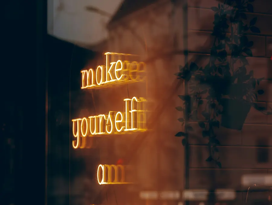A warm glowing sign reading "make yourself a priority"